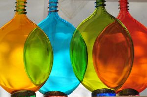 Brightly coloured bottles sit in a line.