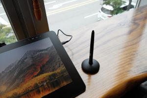 A stylus sits next to a tablet.