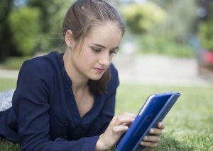 A young woman looks at an iPad.